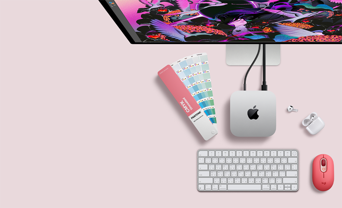 Mac mini, ด้านบน, อะลูมิเนียมสีเงิน, มุมมน, โลโก้ Apple สีดำมันเงาอยู่ตรงกลาง, เชื่อมต่อด้วยสาย, มองเห็น Studio Display ที่ตั้งอยู่ด้านบนบางส่วน, AirPod 4, เปิดฝาอยู่, ตัวเลือกสี Pantone, คีย์บอร์ดและเมาส์ Logitech สีแดง