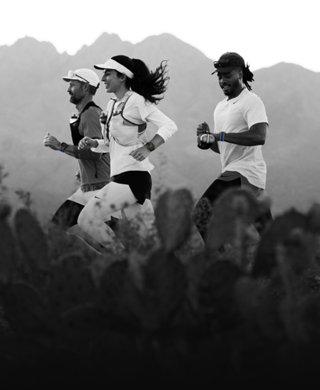 คนสามคนกำลังวิ่งอยู่ในภูมิประเทศแบบภูเขา ทุกคนใส่ Apple Watch Ultra 3