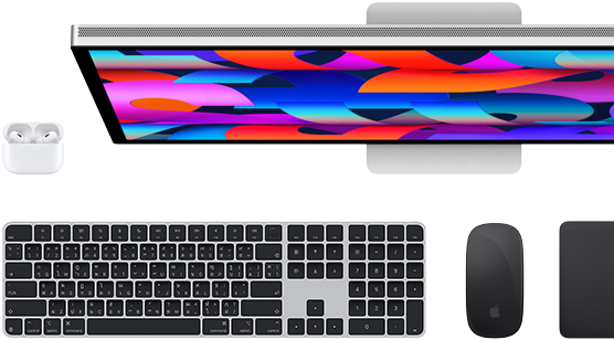 มุมมองจากบนลงล่างของจอภาพ Studio Display, Magic Keyboard สีดำ, Magic Mouse สีดำ, Magic Trackpad สีดำ และเคส AirPods สีขาว